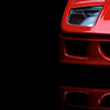 Ein Versuch mit Bodenspiegelung. Ferrari-Modell auf einer Plexiglasplatte vor schwarzem Hintergrundstoff.